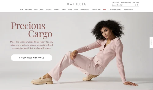 Athleta brand webpage featuring woman in matching ribbed top and pants, kneeling to display outfit and tan loafers against a plain background.