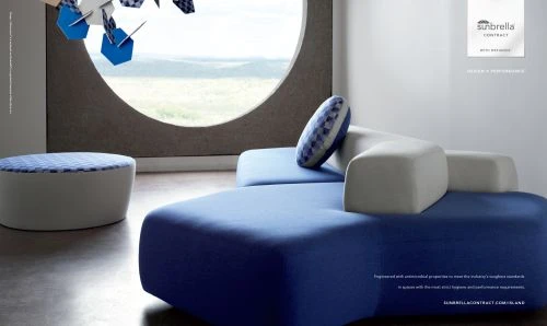 Modern interior design featuring a modular blue and white sofa, ottoman, round window, and geometric hanging decoration for a stylish living space.