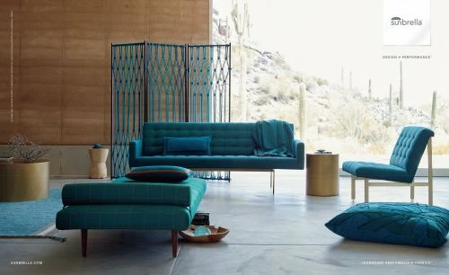 Interior design features a turquoise couch, ottoman, chair, and a decorative screen, complemented by natural light and desert views.