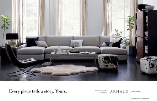 Living room interior featuring a gray sectional sofa, decorative pillows, rug, side chair, and dark wood furniture with bright natural lighting.