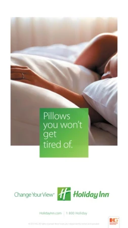 Close-up shot of an adult's arm and hand resting on a white pillow in bed, with Holiday Inn logo and text promoting a comfortable stay.