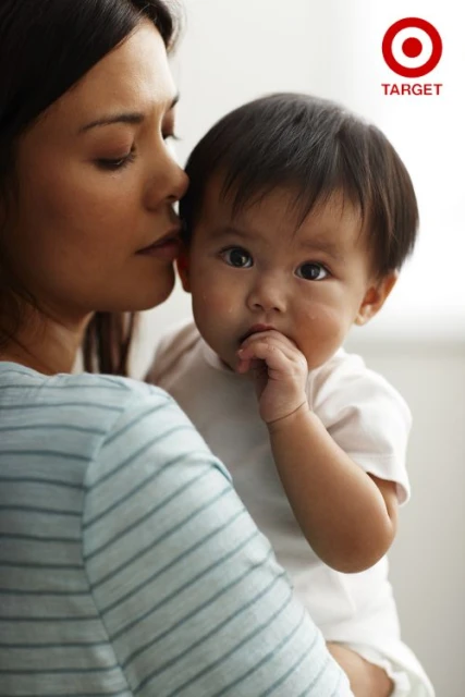 A woman holds an infant, showcasing a tender moment. The image features the Target logo, suggesting an advertisement or brand association.