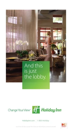 A woman walking through a hotel lobby past a couch and orchid display, photographed by Laurie Frankel.