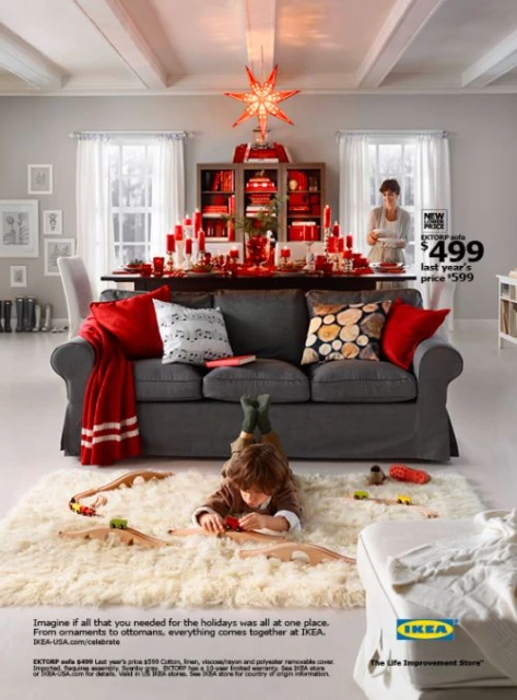 Holiday home interior with a child playing on a fluffy rug near a gray sofa, a festive dining table, and a woman in the background.