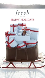 A wooden sled filled with light blue gift boxes tied with red ribbons against a snowy white landscape.