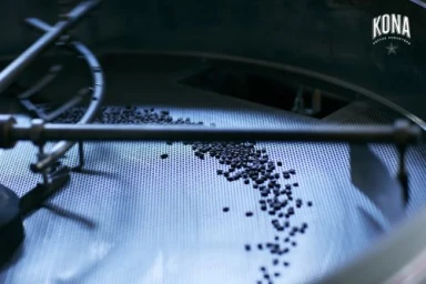 Coffee beans spinning inside a large commercial metal roaster drum photographed by Laurie Frankel.