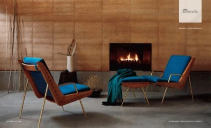 Two blue lounge chairs with wooden frames and brass legs placed in a modern living room interior with a fireplace.