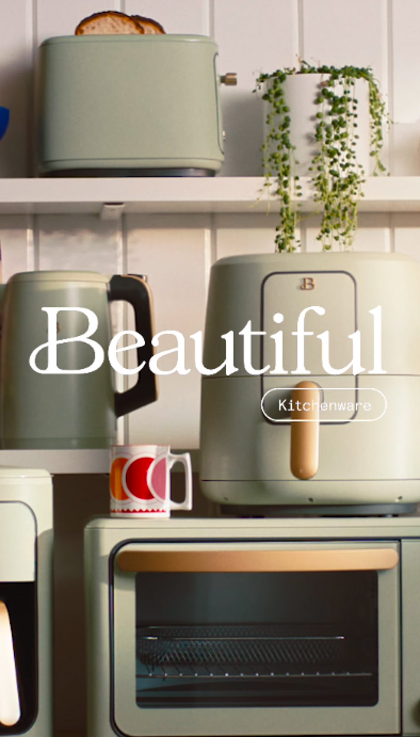 A vertically-oriented product shot features a pastel-colored kitchen appliance collection displayed on a white shelf with a trailing plant.