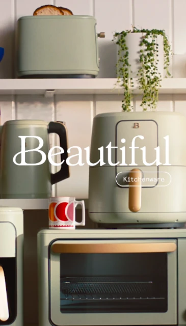 A vertically-oriented product shot features a pastel-colored kitchen appliance collection displayed on a white shelf with a trailing plant.