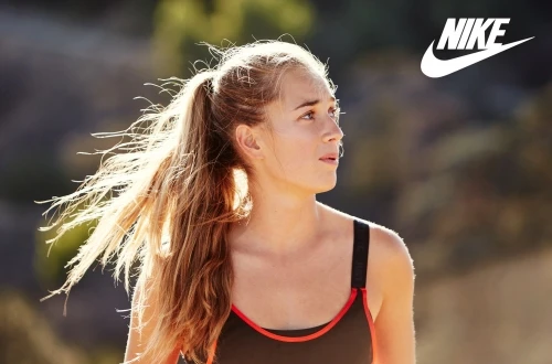 Woman athlete outdoors in sportswear with Nike logo. Close-up of a woman in athletic wear outside in nature with a blurred background.