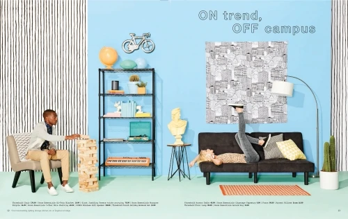 Trendy dorm room interior featuring a male student playing Jenga, a female student reading, furniture, decor, and pastel color scheme.