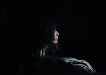 Profile portrait of a woman with dark hair in deep shadow by Joyce Kim