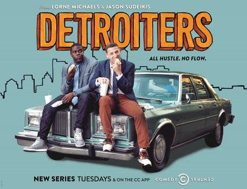 Two men sit atop a vintage car, styled in suits, eating sandwiches, promoting the 'Detroiters' TV series against a teal backdrop.