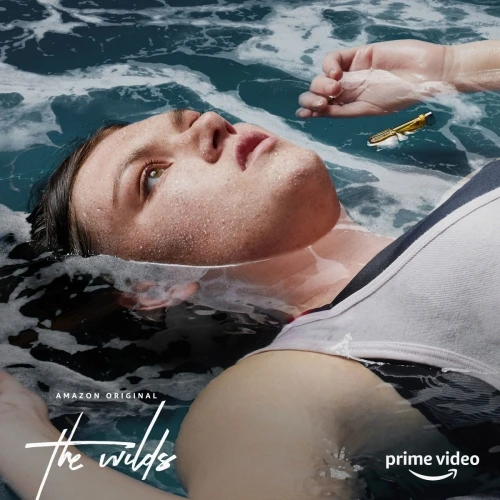 Adult female floats in blue water with wet hair and a white tank top. Ocean has waves in the background with an Amazon Prime logo.