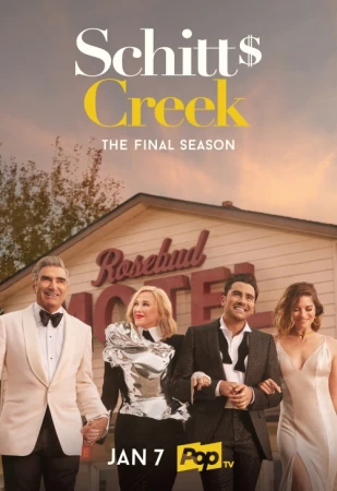 Promotional shot from Schitt's Creek showing four smiling adults in formal wear standing in front of the Rosebud Motel building.