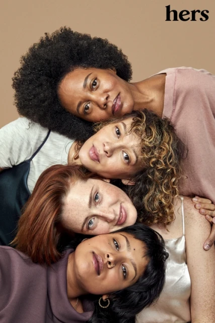 Close-up studio portrait of four diverse young women lying together. Tan background, natural lighting, soft color palette, modern style, 'hers' logo visible.
