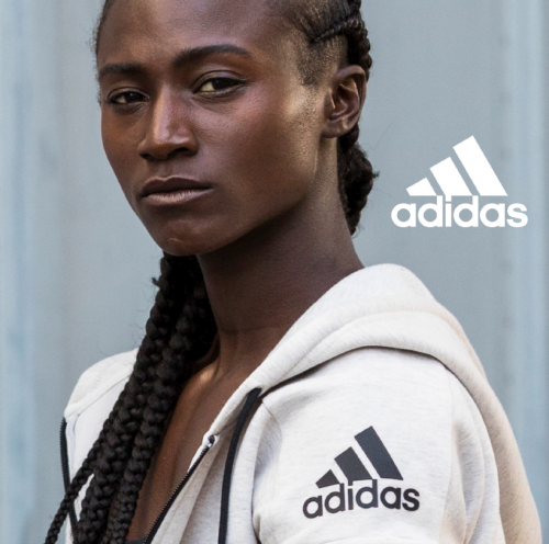 Close-up portrait of a Black woman wearing an off-white hoodie with black drawstrings and an Adidas logo by director Danielle Levitt