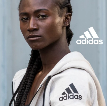Close-up portrait of a Black woman wearing an off-white hoodie with black drawstrings and an Adidas logo by director Danielle Levitt