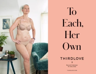Older woman standing in nude lingerie next to a teal armchair in an interior room beside a pink panel with black text.