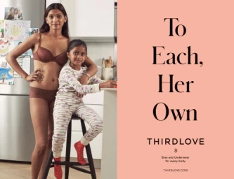 South Asian woman standing next to a young seated girl in patterned pajamas inside a kitchen, directed by Danielle Levitt.