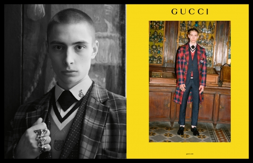 Gucci fashion advertisement featuring a slender male model in plaid suit in a photo studio with warm lighting and set on a yellow backdrop.