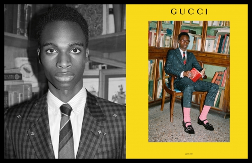 Gucci advertisement features a Black male model in suit next to a photo of him in a suit reading a book in front of a bookshelf.