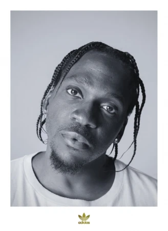 Portrait of a fair-skinned adult man wearing a dark jacket against a dark grey background in a photo studio with studio lighting.