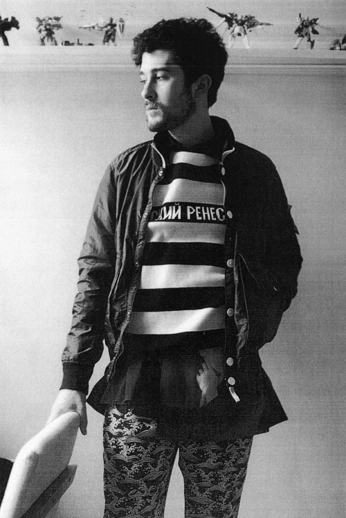 Portrait of a man in patterned trousers and a striped sweater by photographer Ari Marcopoulos in New York.