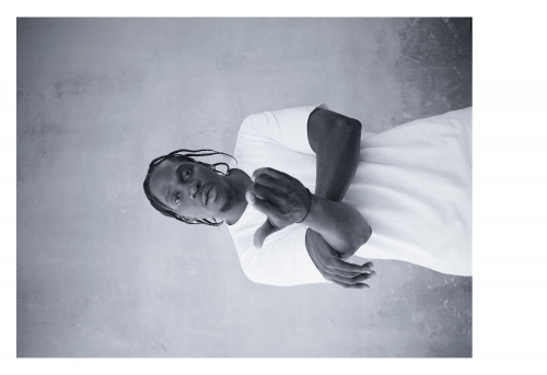 Portrait of a black man with braided hair wearing a white t-shirt by photographer Ari Marcopoulos in New York