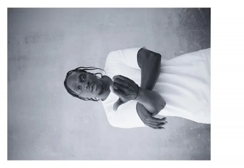 Portrait of a black man with braided hair wearing a white t-shirt by photographer Ari Marcopoulos in New York