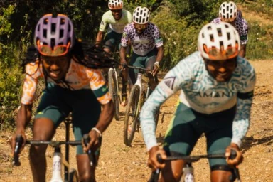 Group of cyclists riding gravel bikes on a dusty dirt path outdoors by photographer Alessandro Simonetti
