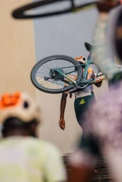 Cyclist carrying bicycle up stone outdoor steps in New York by photographer Alessandro Simonetti