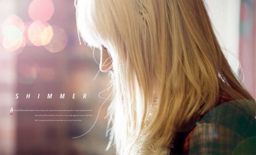 Side view of an adult woman with long blonde hair and fair skin, posing indoors with soft lighting and a bokeh background creating a warm atmosphere.