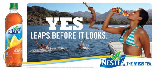 Nestea advertisement featuring a woman drinking iced tea, with people swimming in a lake and mountains in the background on a sunny day.