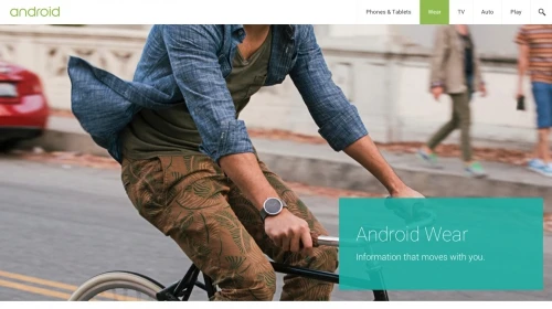 A man rides a bicycle on a city street wearing a smartwatch, with pedestrians visible in the background and an Android Wear advertisement.