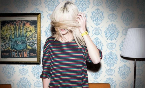 Blonde woman wearing a striped t-shirt with her hair covering her face, photographed by Rennie Solis.