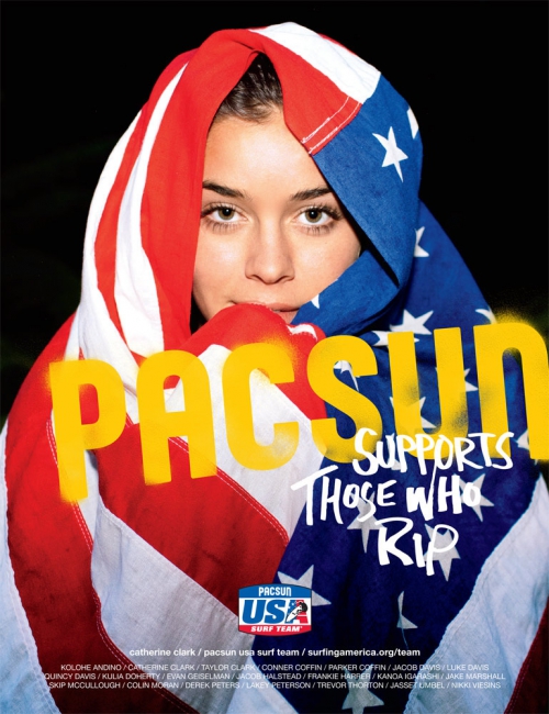 Portrait of a woman wrapped in an American flag, posing with a neutral expression. The image features the PAC-SUN logo and text overlay.
