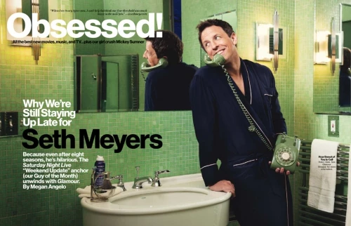 Seth Meyers in a bathroom, posing with a rotary phone and wearing a robe, in a magazine cover editorial shot with a green tiled interior.