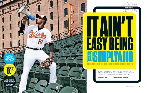 Baseball player in Orioles uniform drinking from a megaphone on stadium seating.  Close-up with stadium architecture in background.