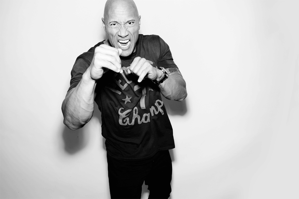 Bald adult male with a determined facial expression, wearing a t-shirt, posed in front of a white backdrop in a studio setting.