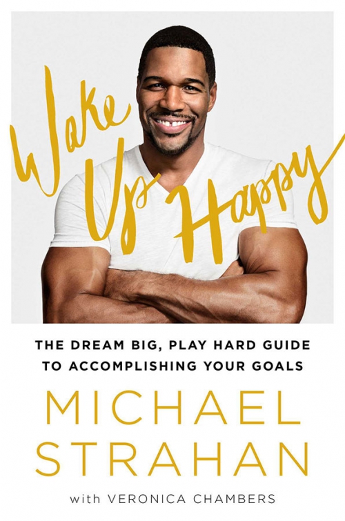 Portrait of Michael Strahan on a book cover. The book title is Wake Up Happy. Strahan is wearing a white shirt and smiling broadly.