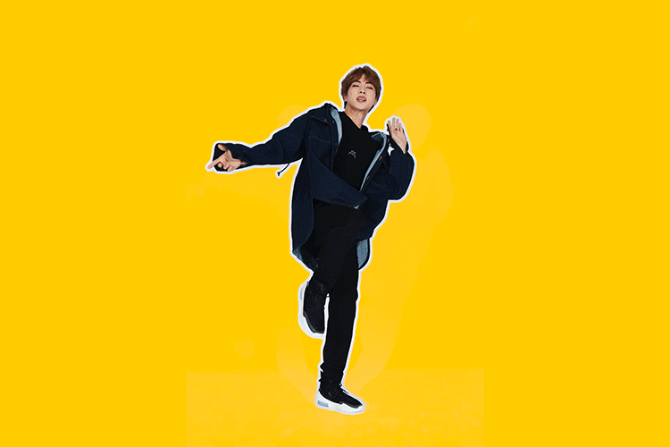 A young adult male dances with arms outstretched against a bright yellow background, wearing a dark blue jacket and black pants and shoes.