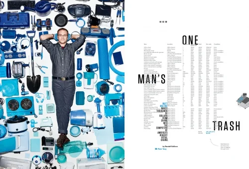 Man lying on a white surface surrounded by an arrangement of various blue objects and household items.