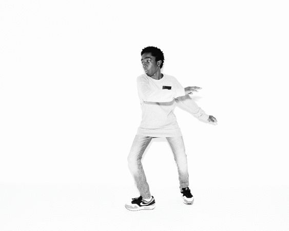 Young black man in a long-sleeve t-shirt and jeans dancing against a white background
