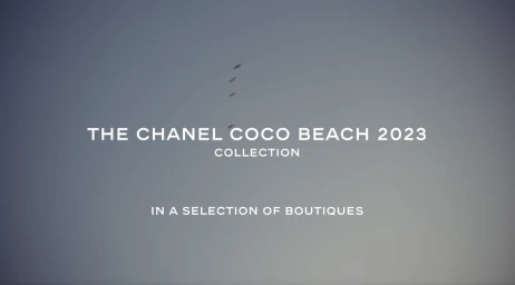A soft gradient sky background displaying crisp white promotional typography for the Chanel Coco Beach 2023 collection.