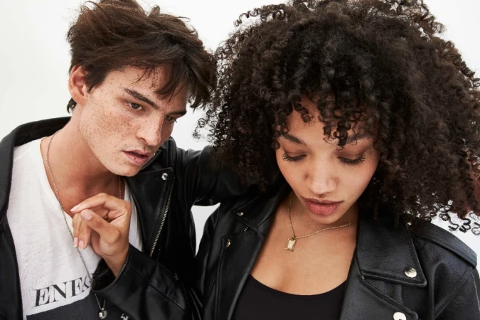 Close-up portrait of two young models in black leather jackets against a clean white background by Larry Bartholomew.