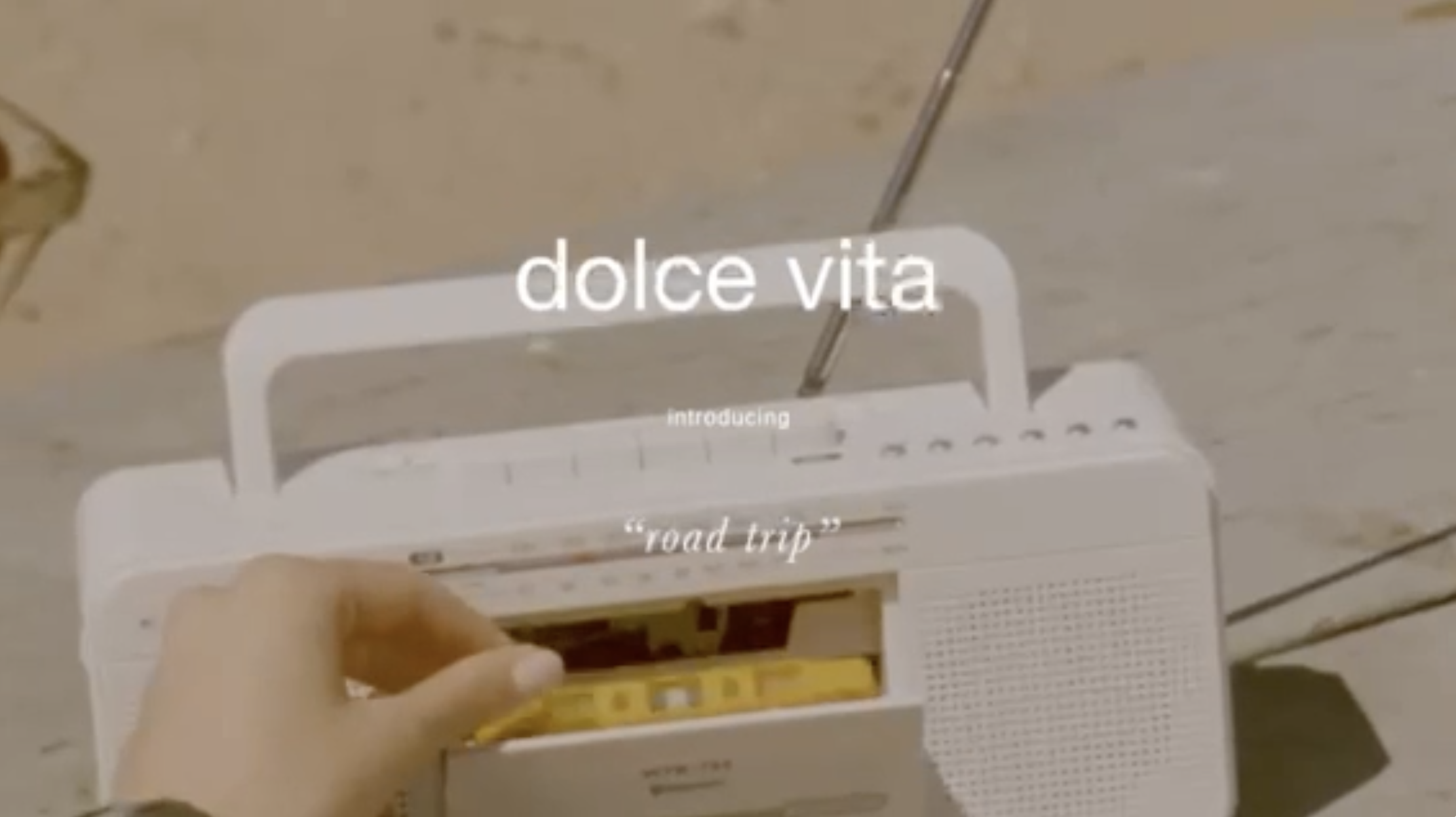 Vintage-style shot of a hand inserting a yellow cassette tape into a white boombox with 'dolce vita' text overlay.