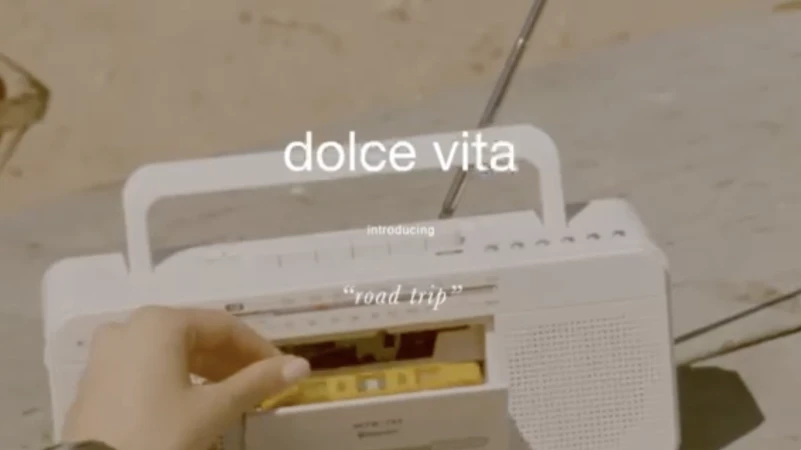 Vintage-style shot of a hand inserting a yellow cassette tape into a white boombox with 'dolce vita' text overlay.