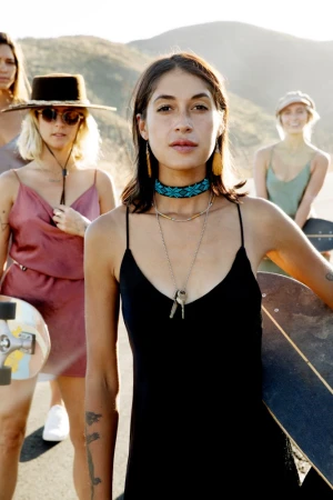 Group of four young women holding skateboards outdoors in a sunny mountain landscape by photographer Cheyenne Ellis.