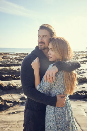 Man and woman embracing on a rocky coastal beach at sunset by photographer Cheyenne Ellis